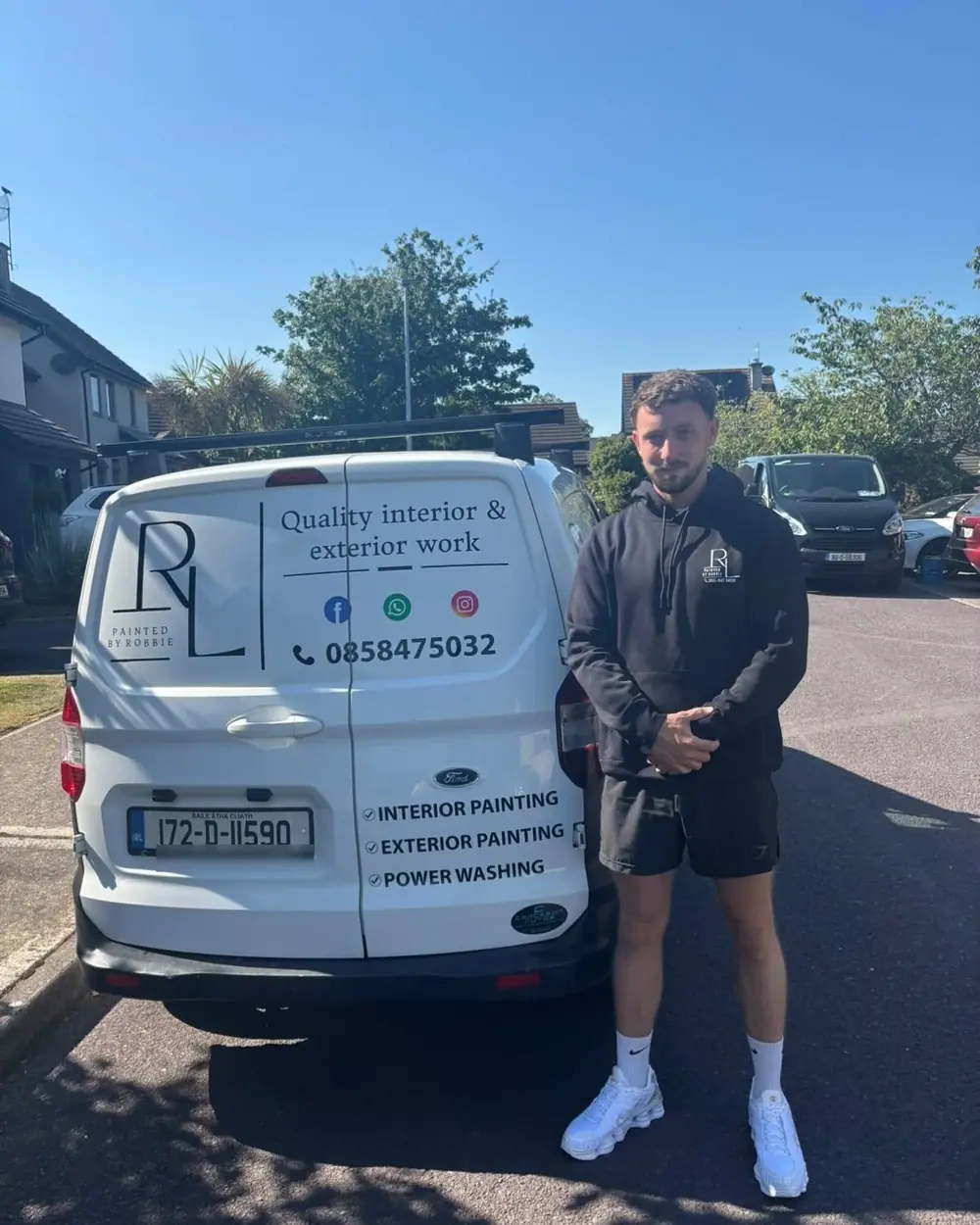 Robbie Leahy standing at the back of his sign-written work van