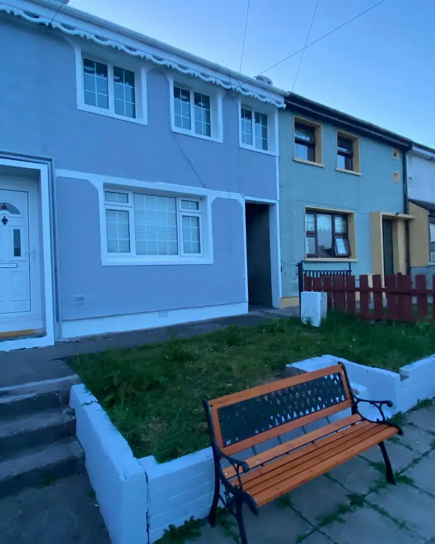 After: the same house finished in Carraig Grey with white garden walls