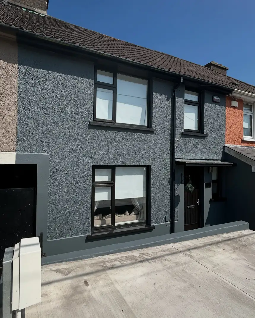 After: the same house in deep charcoal with black surrounds and white windows
