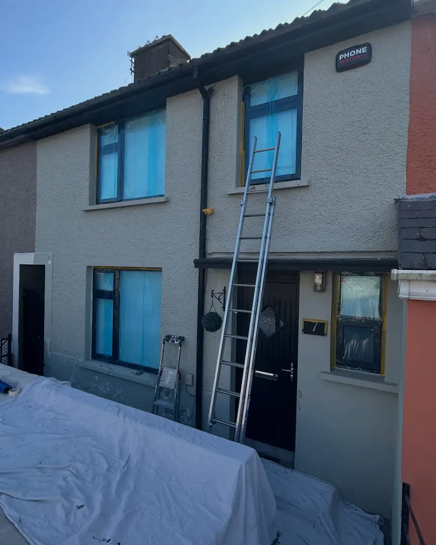 Before: a house in pale grey render with tired window surrounds