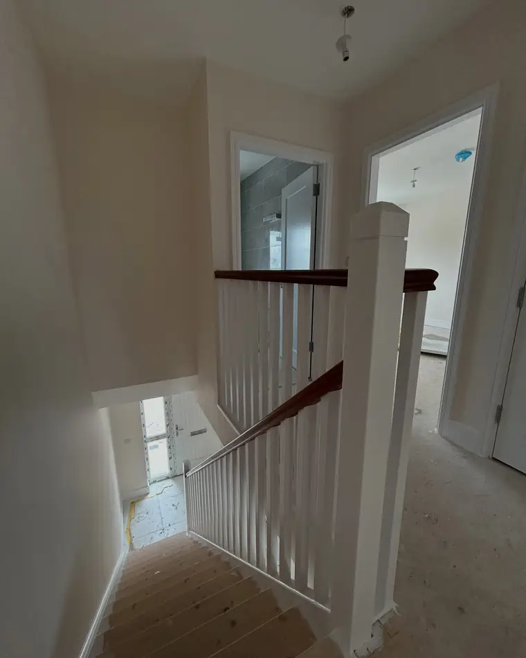 Landing with white spindles and a dark timber handrail
