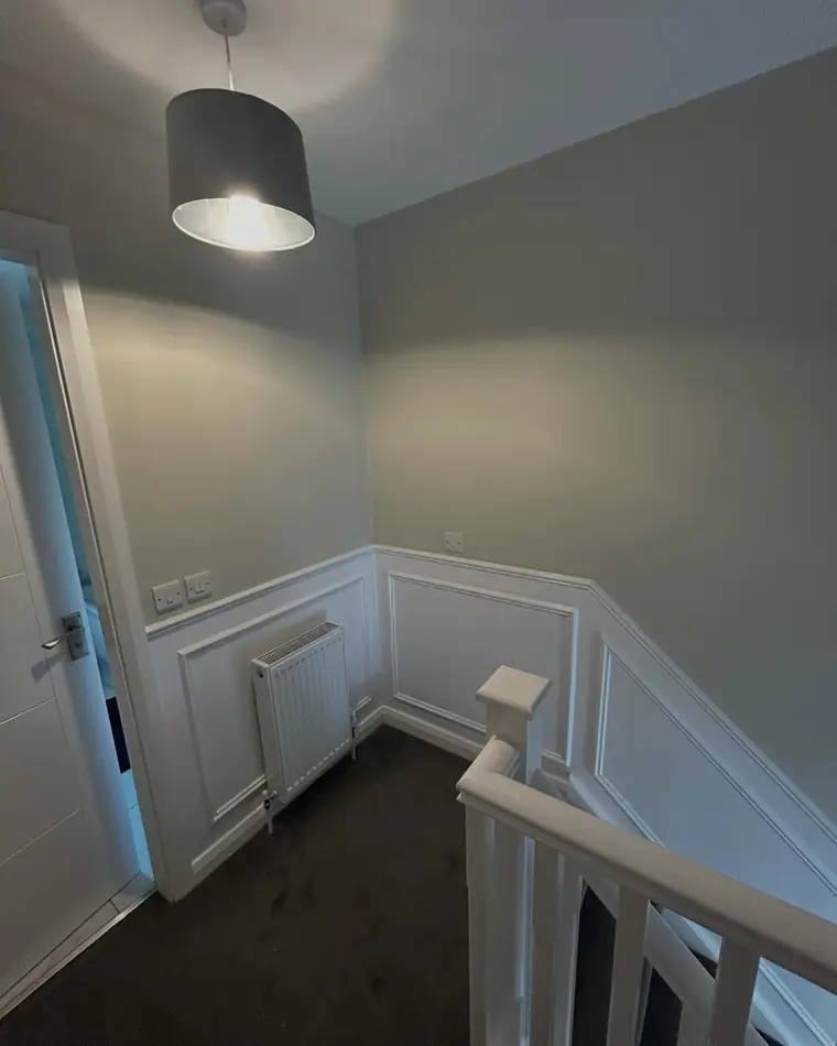 Landing with white wall panelling and a soft grey wall above