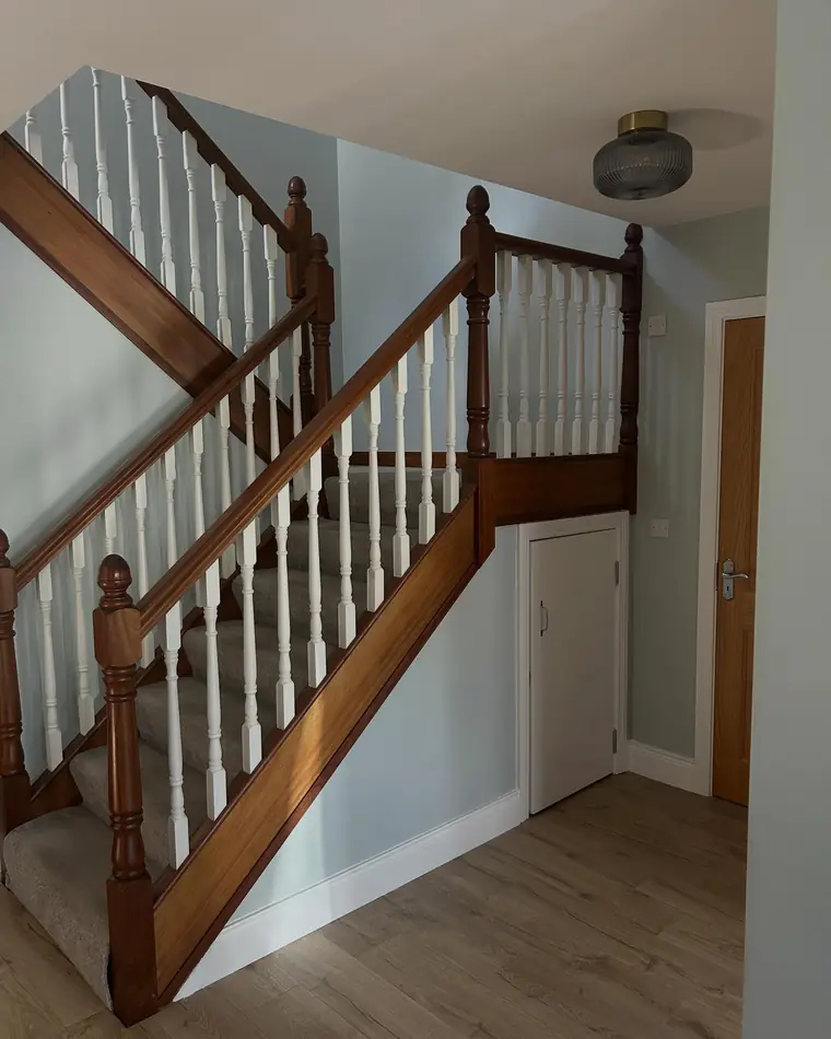 Staircase with a stained timber handrail and white painted spindles