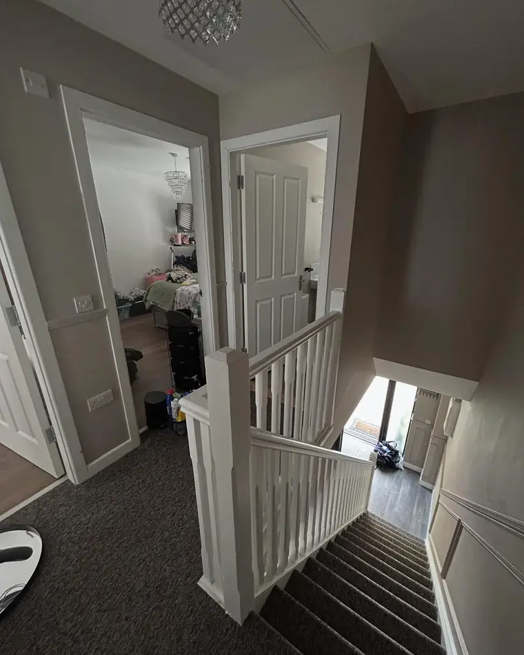 Hall looking through to the stairs, warm grey walls and white doors
