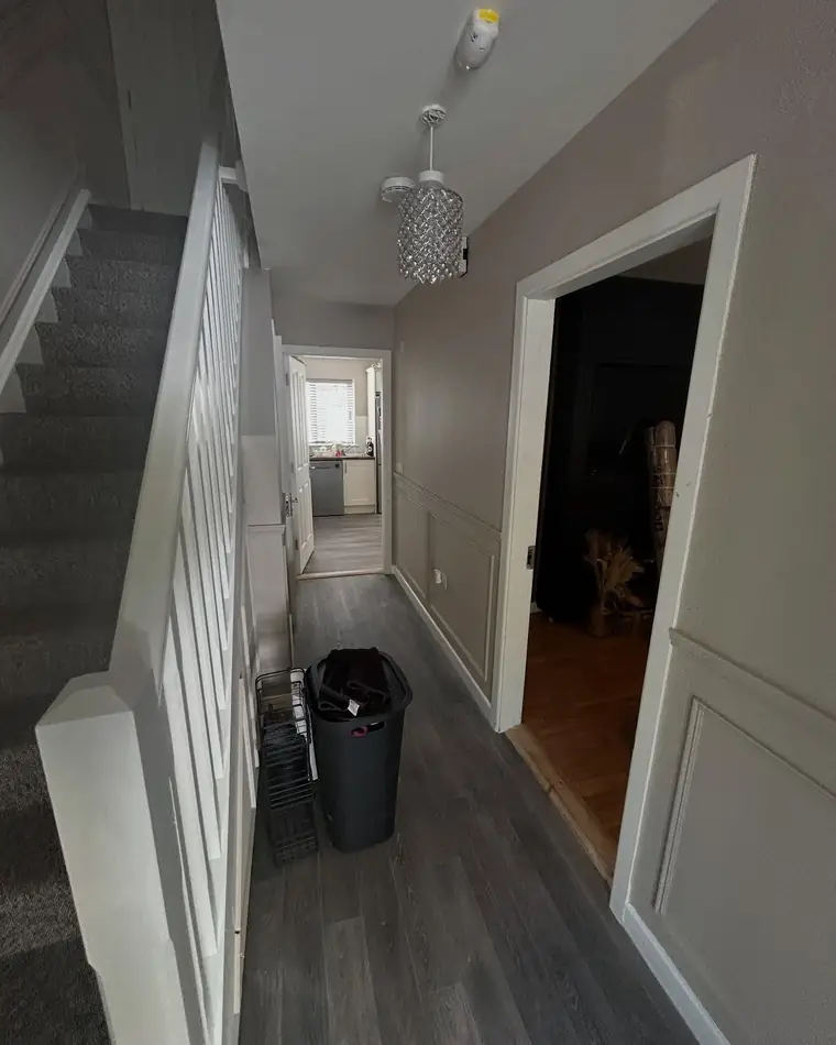 Hall with white panelling to dado height and a warm grey wall above