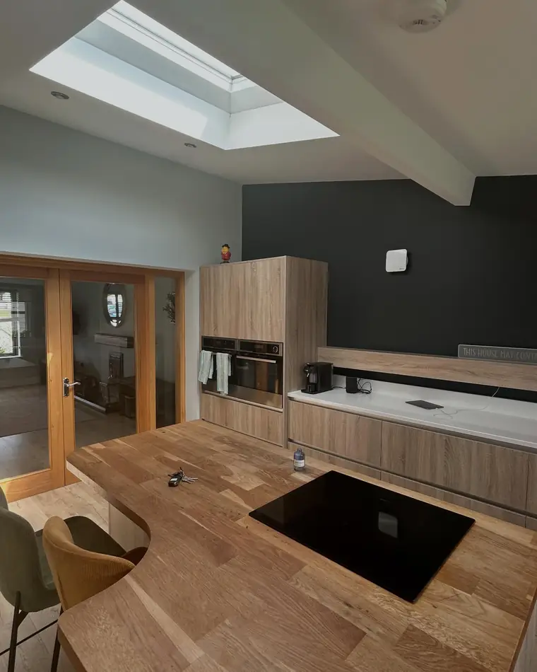 Kitchen and dining area with a flat white ceiling under a skylight