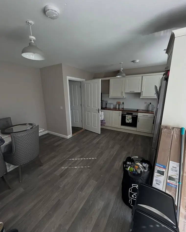 Open kitchen and living space with pale walls and a white ceiling