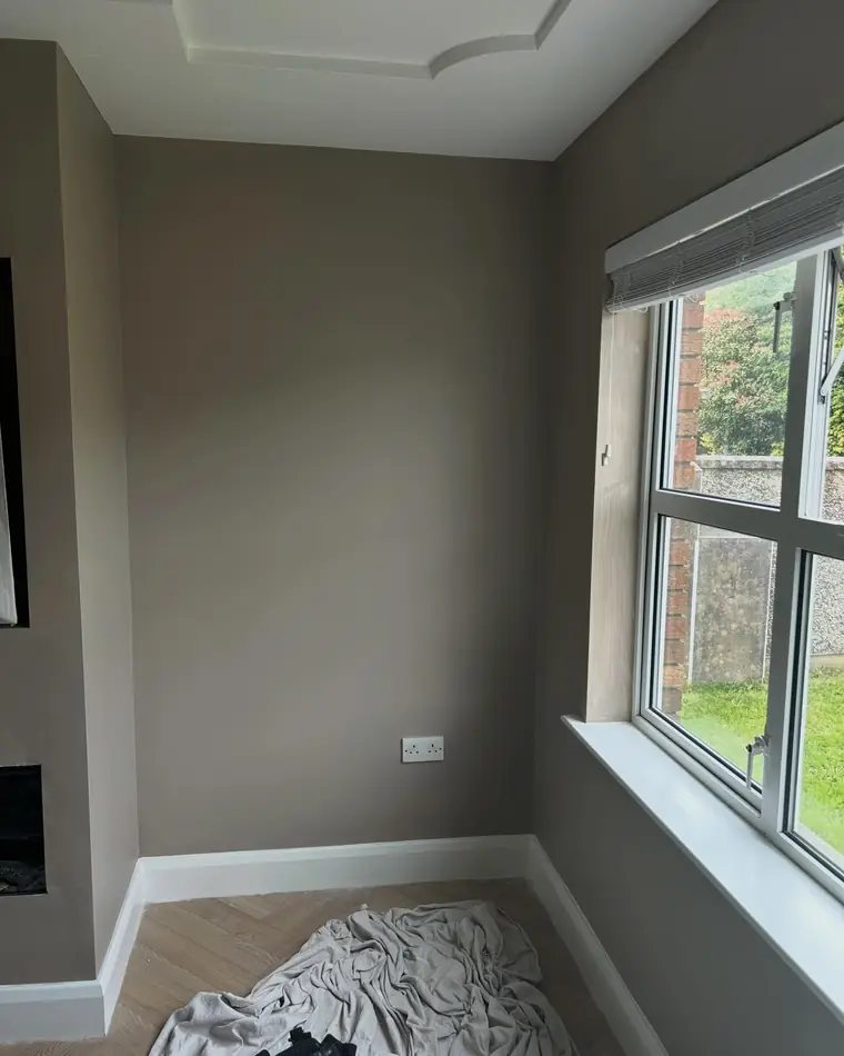 Warm taupe wall with a dark window frame and a white sill