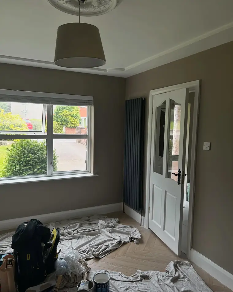 Front room in warm taupe with white woodwork around the door and window