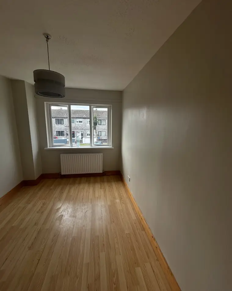 Bedroom freshly painted in a warm neutral under a white ceiling
