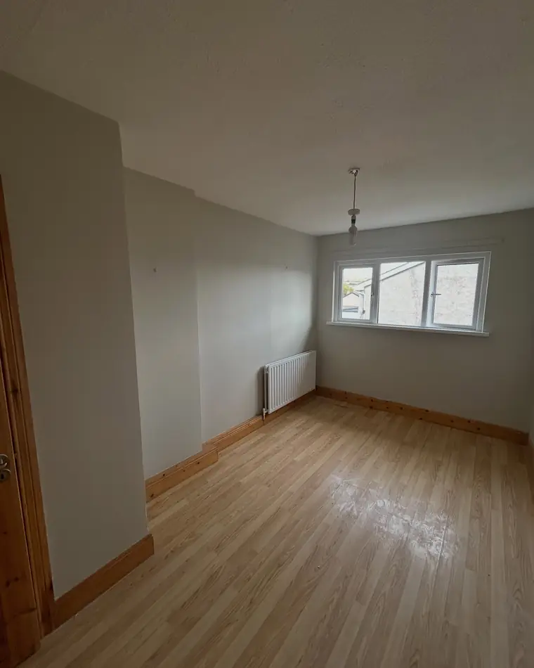 Empty bedroom with clean cut-in lines around the window and door