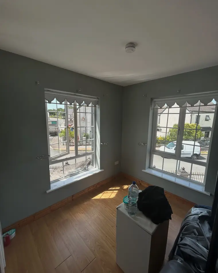 Room painted a smooth grey with two windows and white sills