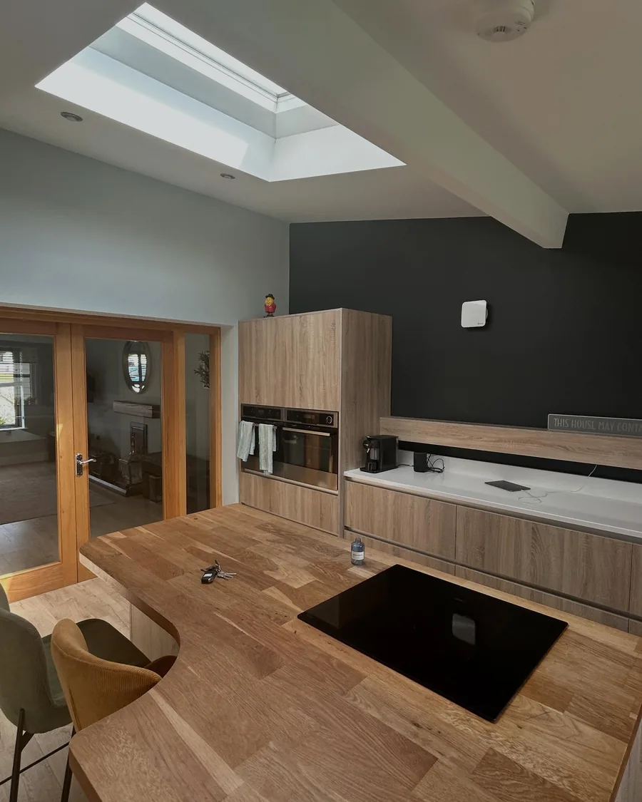 Kitchen and dining area with a flat white ceiling under a skylight