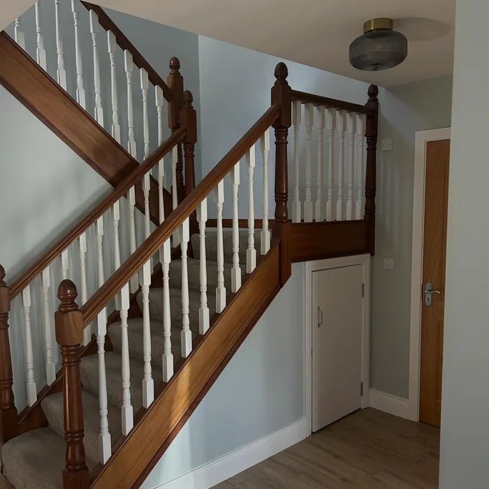 Staircase with a stained timber handrail and white spindles