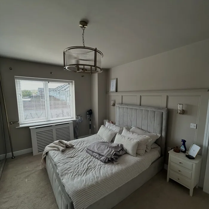 Bedroom finished in a warm grey with white ceiling and woodwork