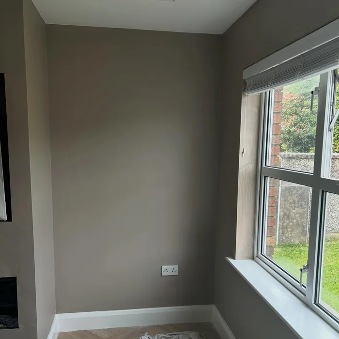 Front room in a warm taupe with a dark window frame and white sill