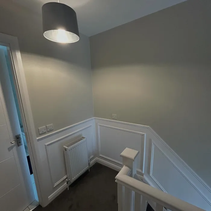 Landing with white wall panelling and a soft grey wall above