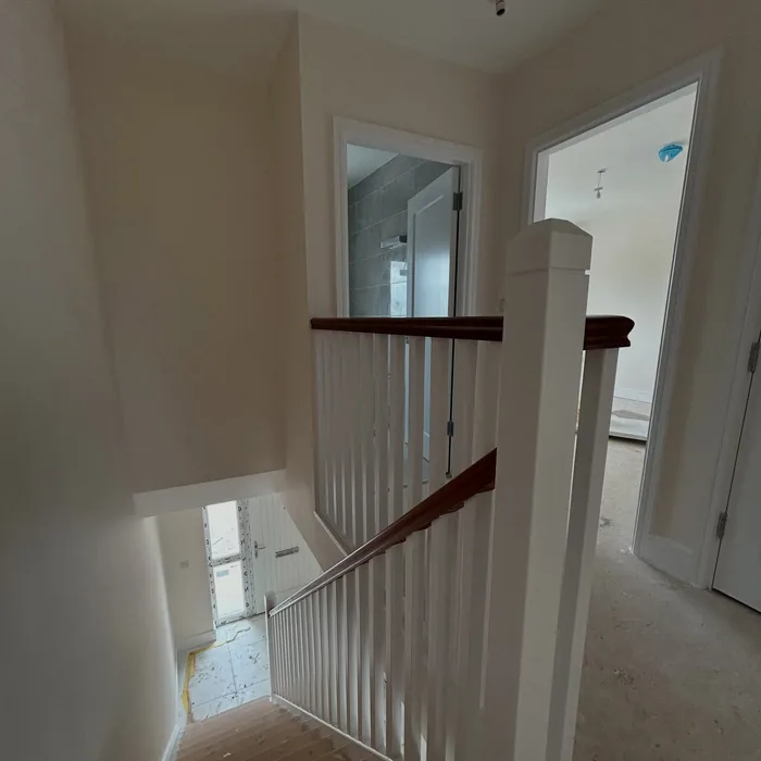 Bright landing with white spindles and a dark timber handrail