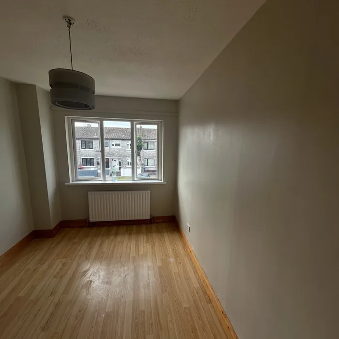 Empty bedroom freshly painted with clean lines around the window